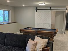 a living room with a pool table and couch