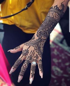 a woman's hand with henna tattoos on it