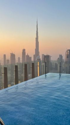 an outdoor swimming pool overlooking the city skyline