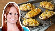 a woman standing in front of a baking pan filled with baked potato skins and cheese