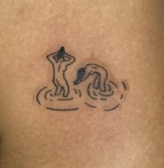 a tattoo on the back of a woman's stomach that has a drawing of a man standing in water