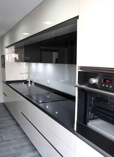 a kitchen with white cabinets and black counter tops, an oven and microwave in it