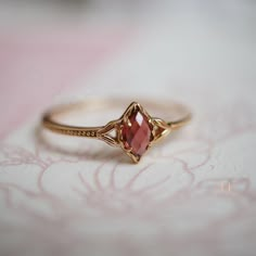 a close up of a ring on a table with a pink flowery cloth in the background