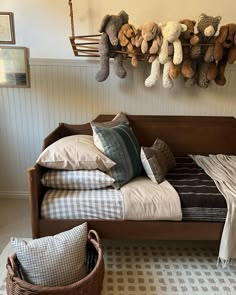 a bed with pillows and stuffed animals hanging on the wall