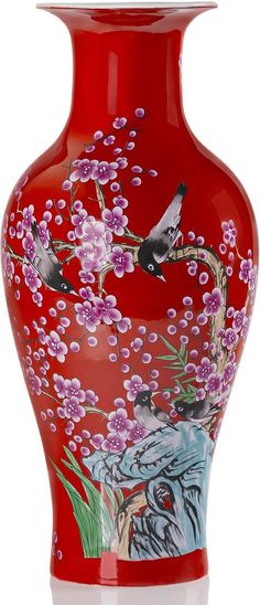 a red vase with birds and flowers painted on it