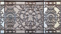 an ornate iron gate on the side of a building