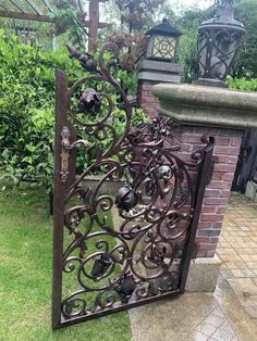 an iron gate in the middle of a garden