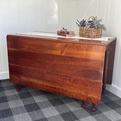 a wooden dresser sitting on top of a carpeted floor next to a basket filled with flowers