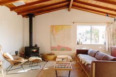 a living room filled with furniture and a wood burning stove in the middle of it