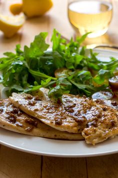 a white plate topped with meat and greens