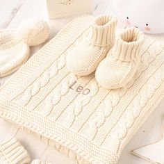 a white knitted blanket and booties on a table