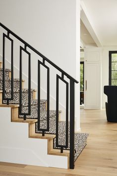 there is a stair case with leopard print carpet on the bottom and handrails