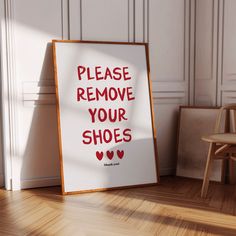 a sign that says please remove your shoes on the floor next to a wooden chair