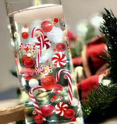 a glass filled with candy canes on top of a table