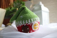 a crocheted christmas ornament with a house on top