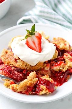 a white plate topped with strawberry shortcakes and whipped cream