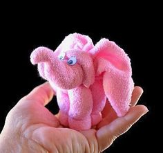 a pink stuffed animal in someone's hand