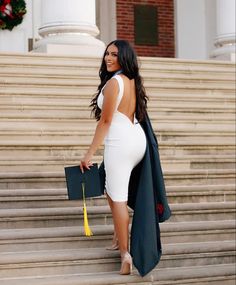 a woman in a white dress is walking down the steps with her hand on her hip