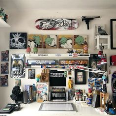 there are many skateboards on the wall above the desk and below it is a computer