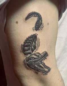 a close up of a person's leg with tattoos on it and an alligator