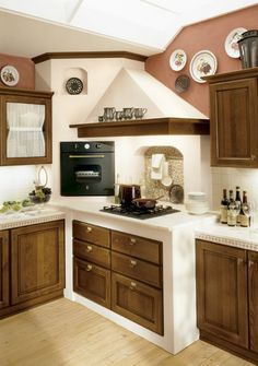 a kitchen with wooden cabinets and white counter tops, along with an oven in the center