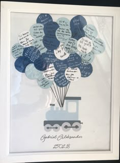 a train with lots of balloons attached to it's side in a white frame