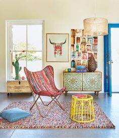 a living room filled with lots of furniture and art on the wall next to a blue door