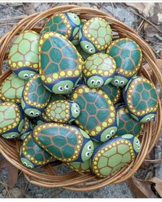 a basket filled with green and yellow painted rocks