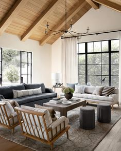 a living room filled with furniture and large windows