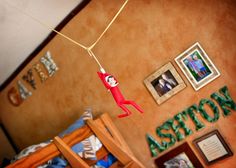 a child's bedroom with pictures on the wall and toys hanging from the ceiling