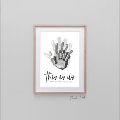 a hand print with the words family in black and white, hanging on a wall