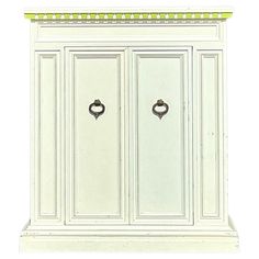 a white cabinet with two doors and green trimmings on the top, in front of a white background