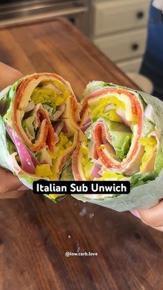 a person holding a sandwich with lettuce, tomato and other vegetables in it