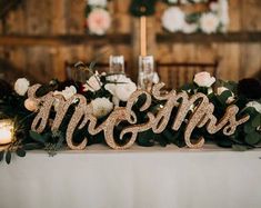 the bride and groom's name spelled with gold glitter on their wedding day table