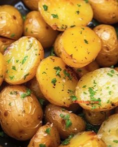 cooked potatoes with parsley on top in a black bowl, ready to be eaten