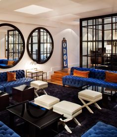 a living room filled with blue couches and mirrors