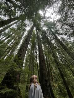 a woman standing in the middle of a forest