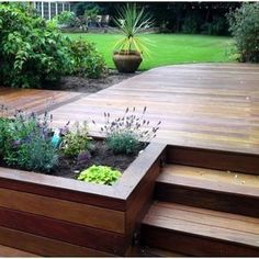 a wooden deck surrounded by plants and trees