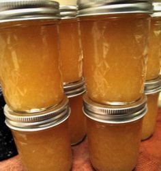 four jars filled with honey sitting on top of a table