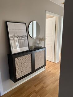 an empty room with a wooden floor and a black cabinet next to a white door