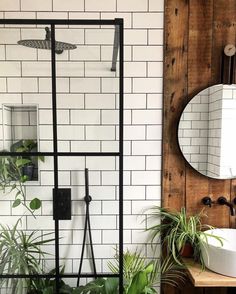 the bathroom is decorated in white and black tile, with green plants on the counter