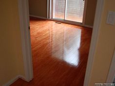 an empty room with hard wood floors and sliding glass doors