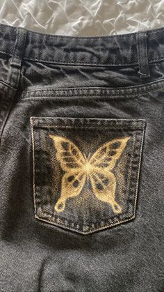 the back pocket of a pair of jeans with an embroidered butterfly on it's side