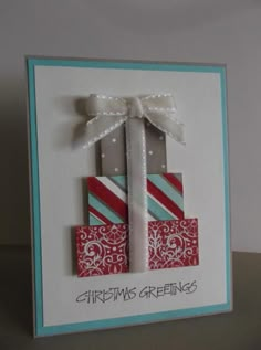 a handmade christmas card with two wrapped presents on top of each other and the words, christmas greetings?