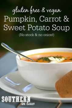 a bowl of pumpkin carrot and sweet potato soup on a white plate with a spoon