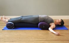 a woman is laying on her stomach while doing an upward back stretch with a yoga mat in front of her