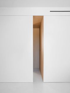 an open door in the middle of a white room