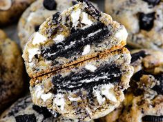 an oreo cookie with chocolate chips and white frosting on top, surrounded by other cookies