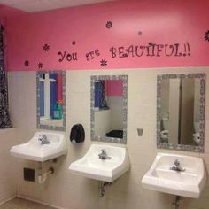 a bathroom with three sinks and mirrors on the wall above them is decorated with words that spell out, you are beautiful