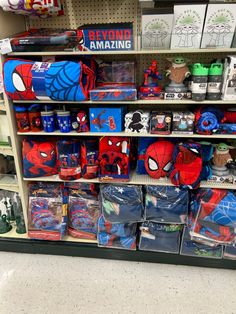 there are many spiderman toys on the shelves in this store, and one is for sale